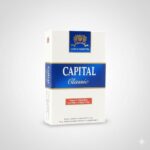 ซองบุหรี่ Capital Classic สีขาวแถบน้ำเงิน ดีไซน์คลาสสิก วางบนพื้นหลังสีเทาสว่าง